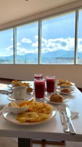 a table with plates of food and drinks on it at HOTEL HOME in Pasto