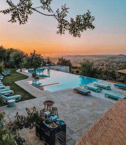 a large swimming pool with a sunset in the background at Abdelli Terraces in Batroun in Batroûn