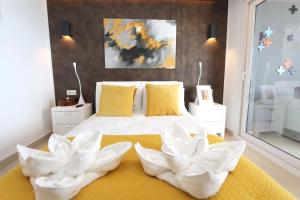- une chambre avec un lit et 2 fleurs blanches dans l'établissement Luxury Panorama Mar by Grupo Quattro, à Punta Prima