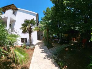 a white house with trees in front of it at New Wellness & Spa Boutique Residence Rovinj in Rovinj