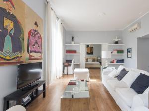 a living room with a white couch and a tv at Auditorium Luxury Apartments in Rome