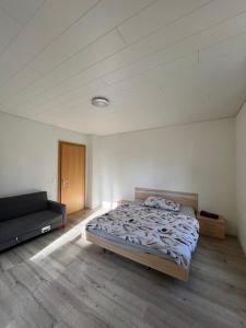 a bedroom with a bed and a couch in it at Pension des Draizes in Neuchâtel