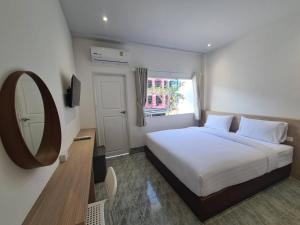 a bedroom with a white bed and a mirror at Triple D Hotel in Betong