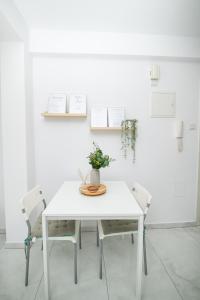 a white table with two chairs and a vase on it at Quattro City Center Ap 501B in Larnaka
