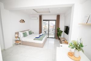 a white living room with a bed and a tv at Quattro City Center Ap 501B in Larnaka