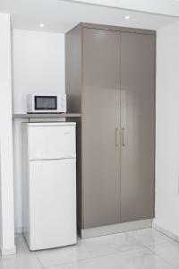 a kitchen with a white refrigerator and a microwave at Quattro City Center Ap 501B in Larnaka