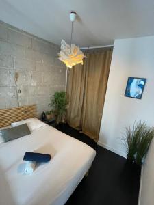 a bedroom with a large white bed and a chandelier at La Grande Madeleine in Nantes