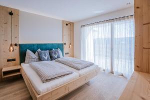 a bedroom with a large bed and a large window at Chalets Hansleitner in Terento