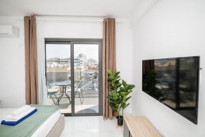 a bedroom with a bed and a balcony with a table at Quattro City Center Ap 501B in Larnaka