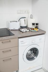 a white washing machine in a kitchen with a counter at Quattro City Center Ap 501B in Larnaka
