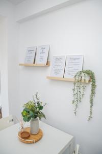 a white table with plants and signs on the wall at Quattro City Center Ap 501B in Larnaka