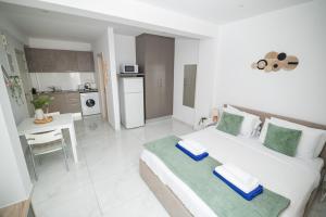 a white bedroom with a bed and a kitchen at Quattro City Center Ap 501B in Larnaka