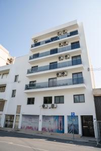 a white building with windows and a street at Quattro City Center Ap 501B in Larnaka