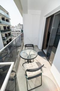 a glass table and chairs on a balcony at Quattro City Center Ap 501B in Larnaka
