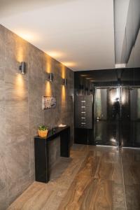 a lobby with a black counter and a wall with tiles at Quattro City Center Ap 501B in Larnaka