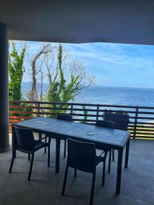 uma mesa e cadeiras numa varanda com o oceano em Baia Vallugola Exclusive Apartment em Castel di Mezzo
