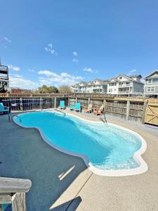 a large swimming pool with blue chairs and condos at KD1105- Feels So Wright in Kill Devil Hills
