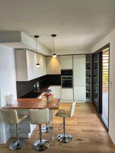 uma cozinha com uma mesa de madeira e cadeiras em Baia Vallugola Exclusive Apartment em Castel di Mezzo