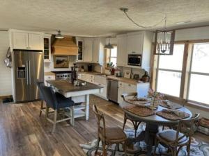 a kitchen with a table and some chairs and a table and a kitchen with at Current River Getaway in Van Buren