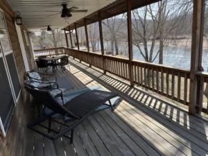 a screened porch with a table and chairs on it at Current River Getaway in Van Buren