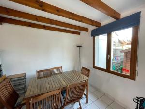 a dining room with a wooden table and chairs at Villa Capbreton, 4 pièces, 6 personnes - FR-1-413-114 in Capbreton