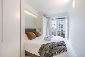 een slaapkamer met een bed en een groot raam bij Pleasant apartment with frontal sea view in Middelkerke