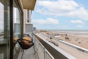 een balkon met stoelen en uitzicht op het strand bij Pleasant apartment with frontal sea view in Middelkerke