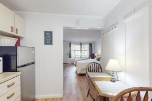 Una cocina con una mesa y una habitación con una cama. en Dogwood - Unit 603, en Flat Rock