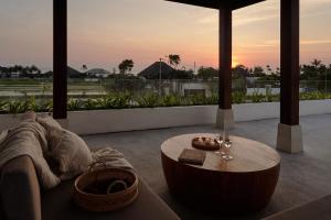 a living room with a couch and a table at Om Cemagi Beach Villa Canggu in Canggu