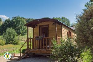 una piccola cabina in legno con portico in un campo di Gite les Ecureuils a Herbeys