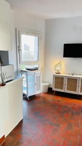 a living room with a tiled floor and a television at Studio Saint-Cyprien Port in Saint-Cyprien