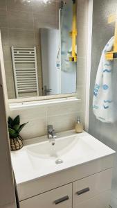 La salle de bains est pourvue d'un lavabo blanc et d'un miroir. dans l'établissement Studio Saint-Cyprien Port, à Saint-Cyprien