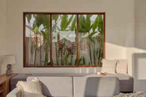 un soggiorno con divano e una grande finestra di Om Cemagi Beach Villa a Tanah Lot