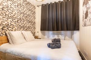 a bedroom with a white bed with a black curtain at L'Anneciano - Balcon - Chambre - Vue in Annecy
