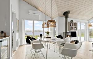 a dining room with a table and white chairs at Stunning Home In Haderslev With House Sea View in Haderslev