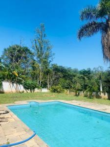 uma grande piscina azul num quintal em Chácara com Piscina e Amplo Quintal em Embu