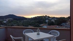 a table and chairs on a balcony with the sunset at Consumella24 in Portoferraio