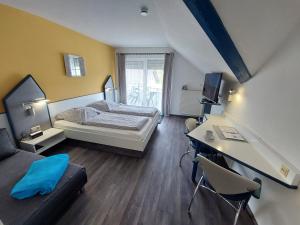 a bedroom with a bed and a desk with a computer at Hotelpension Gästehaus Birgit in Bad Mergentheim +96 photos