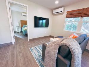 Una sala de estar con un sofá y un televisor de pantalla plana. en Hidden Beach Bungalow, en New Smyrna Beach