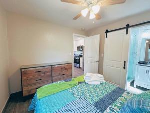 Un dormitorio con una cama y un ventilador de techo. en Hidden Beach Bungalow, en New Smyrna Beach