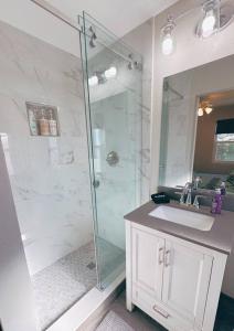 Un baño con ducha de cristal y lavabo. en Hidden Beach Bungalow, en New Smyrna Beach