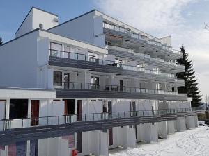 un gran edificio blanco con un puente delante en Wald Apartments im Predigtstuhl Resort en Sankt Englmar