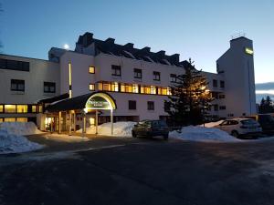 un grande edificio con auto parcheggiate in un parcheggio di Wald Apartments im Predigtstuhl Resort a Sankt Englmar