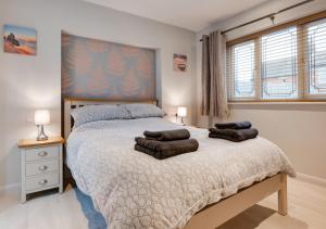 una camera da letto con un letto con tre cuscini sopra di Malthouse Lodge a Heacham