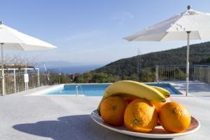 a plate of fruit on a table next to a pool at Apartments Rajkovic in Labin