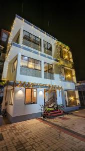 a large white building with christmas lights on it at Janardhana Residency in Dharmastala