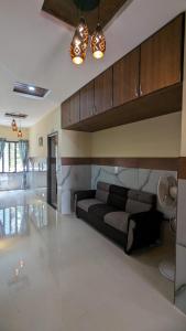 een woonkamer met een zwarte bank in een kamer bij Janardhana Residency in Dharmastala