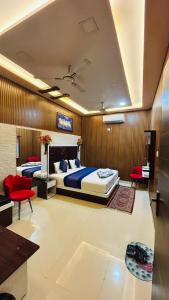 a bedroom with a bed and a couch and chairs at Hotel Ankit Near Assi Ghat in Varanasi