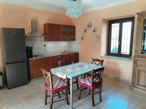 een keuken met een tafel met stoelen en een koelkast bij VILLA SAMUELA in Neive