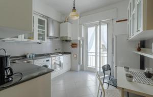 una cucina bianca con elettrodomestici bianchi e una finestra di 4 Bedroom Awesome Apartment In Imperia a Imperia